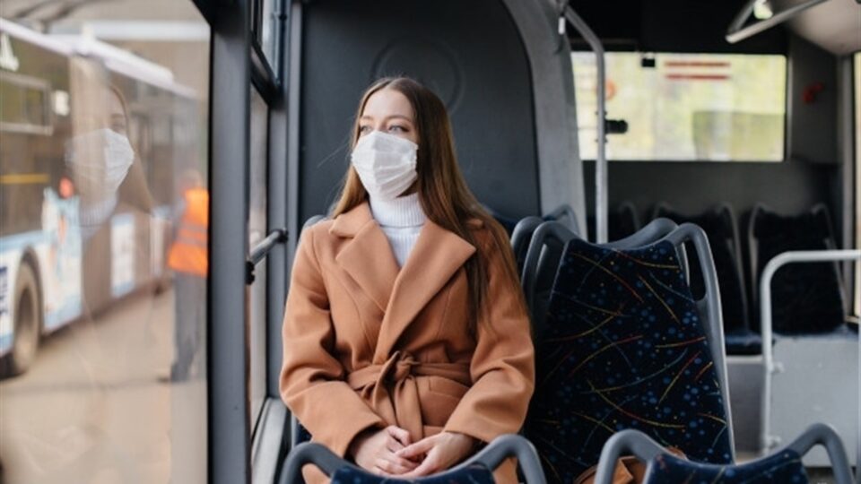 Жінка в масці їде в громадському транспорті